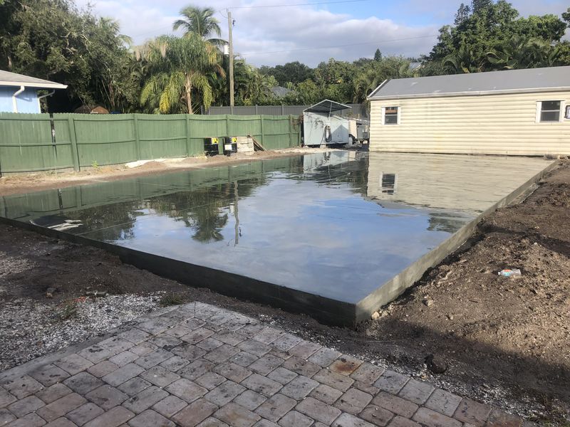 Finished backyard slab meeting an existing paver patio