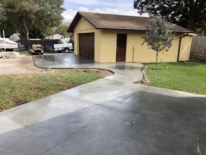 Curved concrete walkway leading to a detached garage